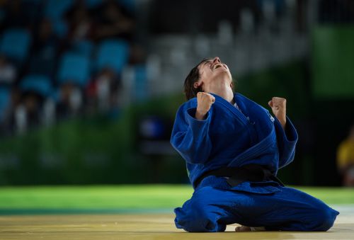 Sandrine Martinet of France kneels on the mat with her fists clenched after winning gold at the Rio 2016 Paralympics